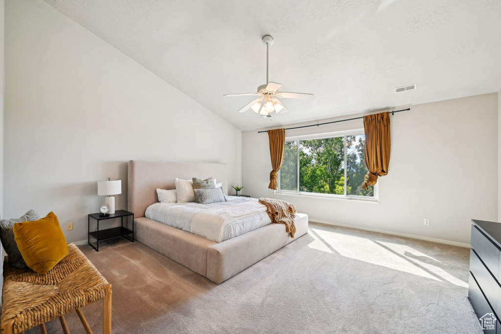 Bedroom featuring carpet flooring, vaulted ceiling, baseboards, and a ceiling fan