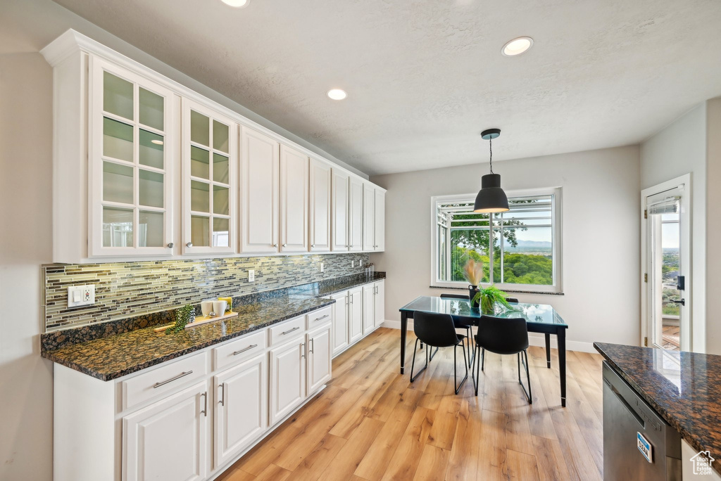 Kitchen with stainless steel dishwasher, white cabinetry, decorative backsplash, glass insert cabinets, and recessed lighting