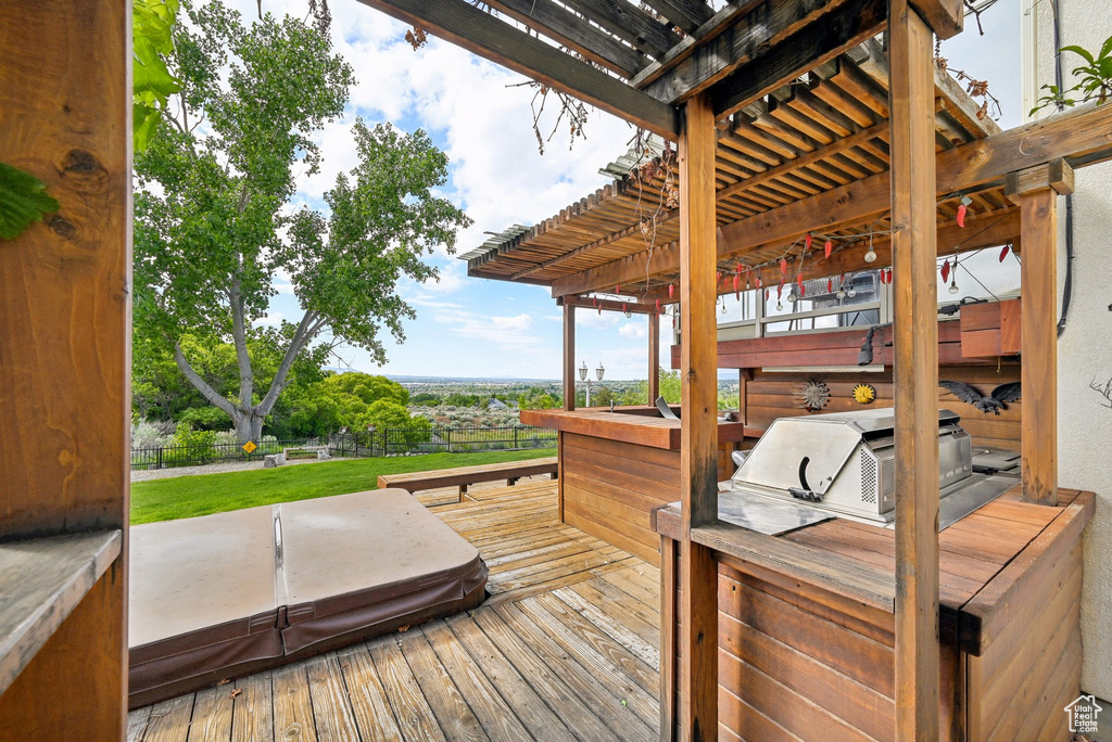 Wooden terrace featuring a covered hot tub and a pergola