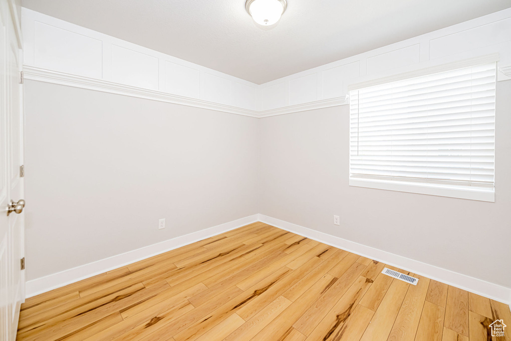 Unfurnished room with baseboards and hardwood / wood-style flooring