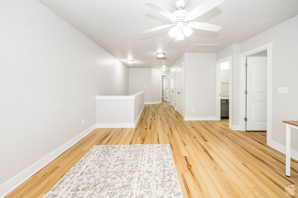 Empty room featuring light wood-style flooring, ceiling fan, and baseboards