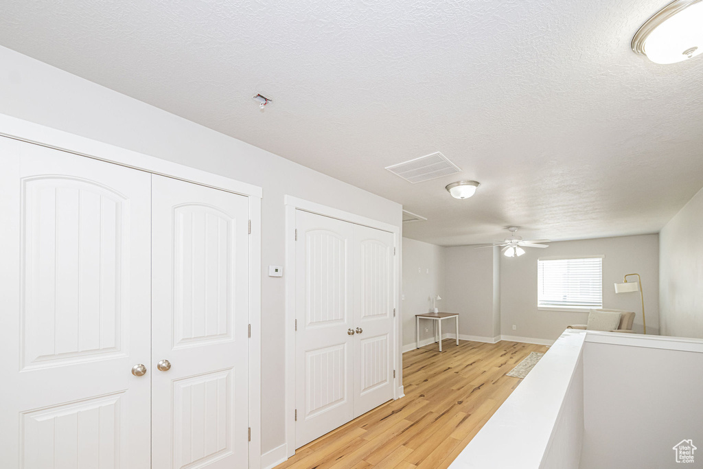 Hall with light wood-style flooring and baseboards