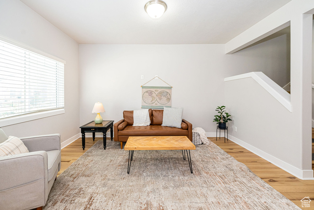 Sitting room featuring wood finished floors, baseboards, and stairs