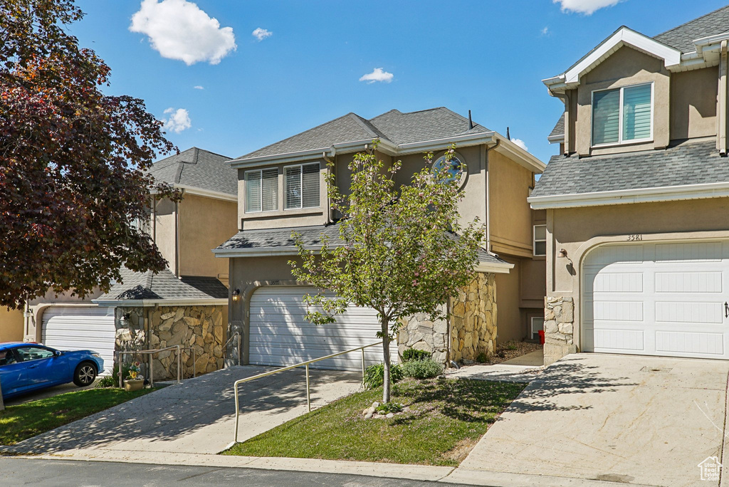 Traditional-style house with driveway and stucco siding