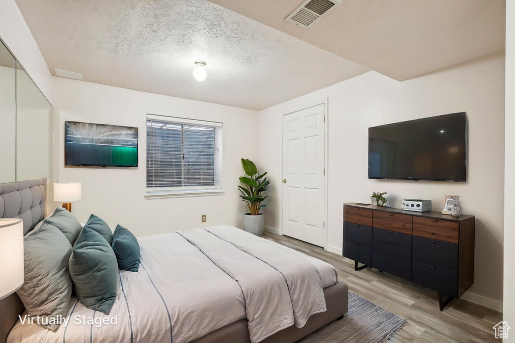 Bedroom with light wood-style flooring and baseboards