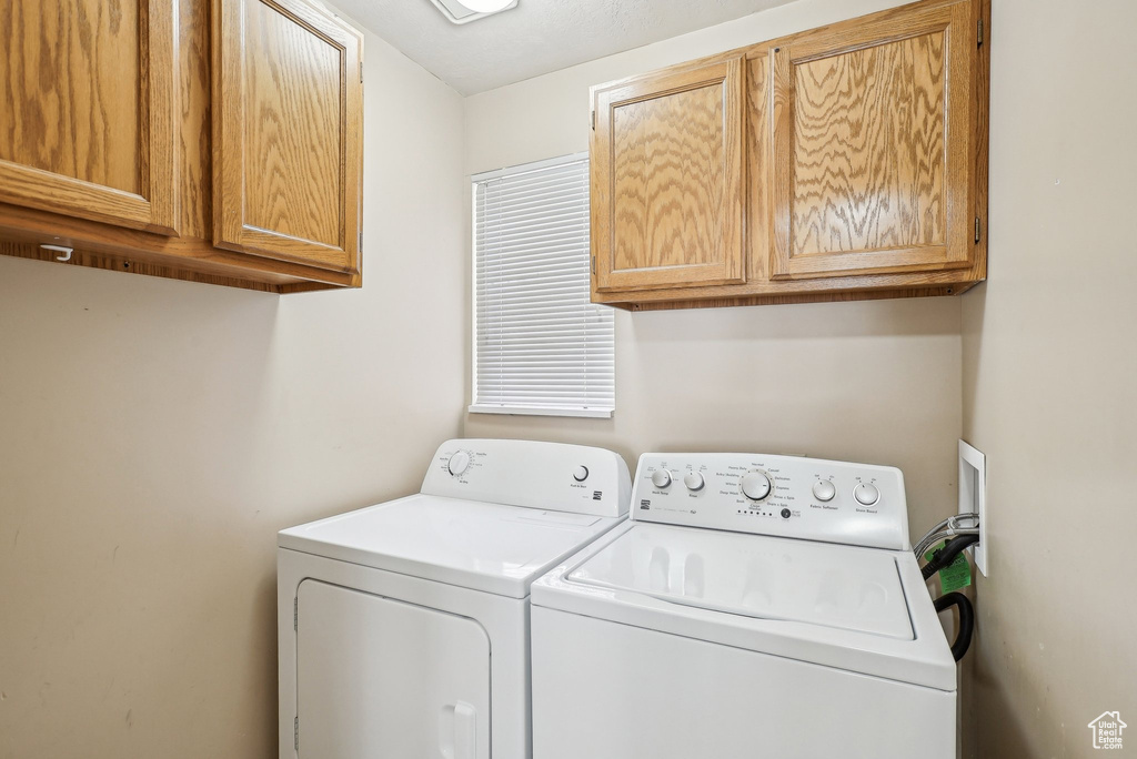 Laundry room featuring washer and clothes dryer and cabinet space