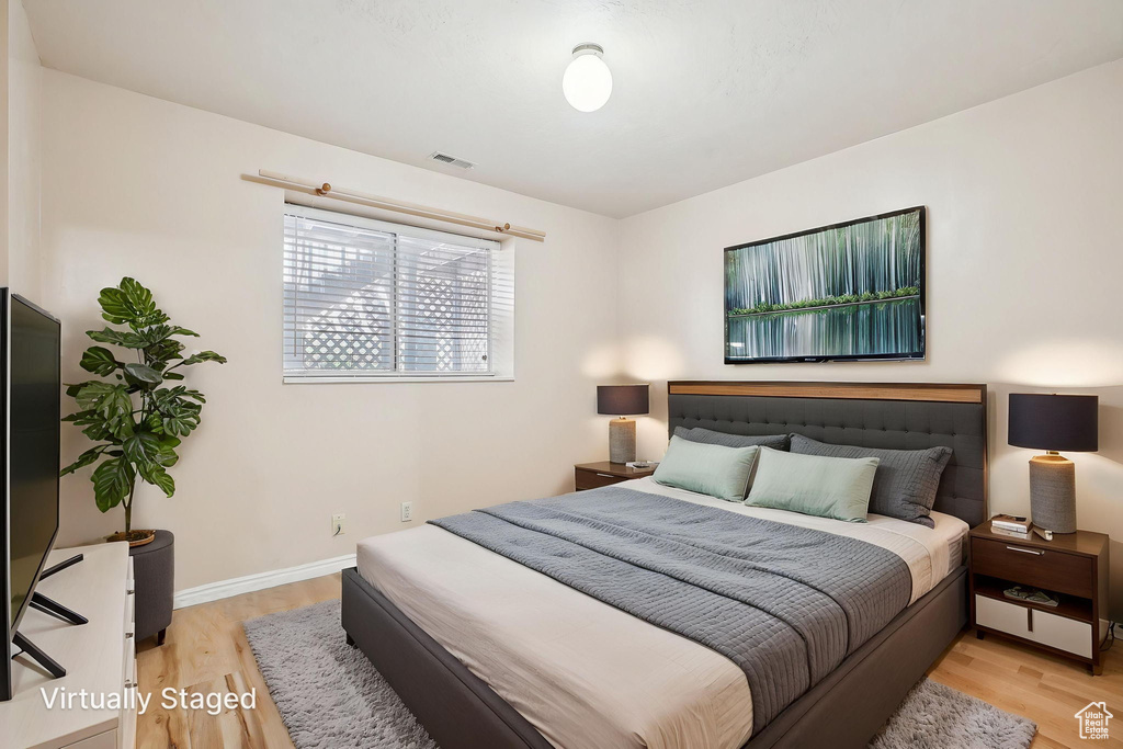 Bedroom with light wood-style floors and baseboards