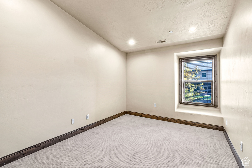 Carpeted empty room with baseboards and recessed lighting