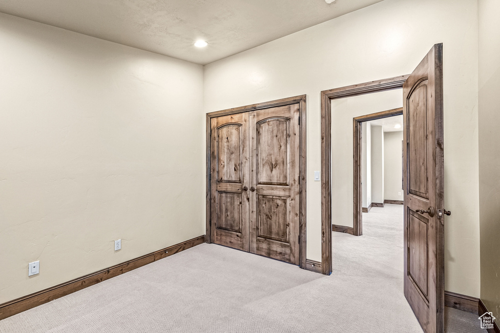 Bedroom featuring light carpet and baseboards