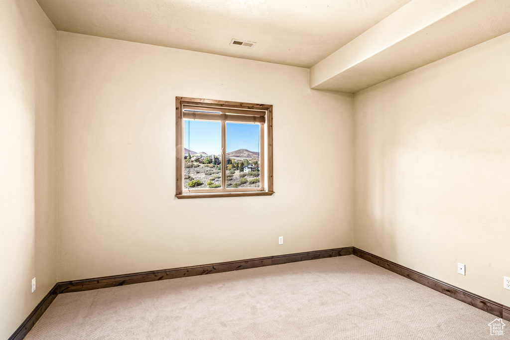 Spare room featuring carpet floors and baseboards