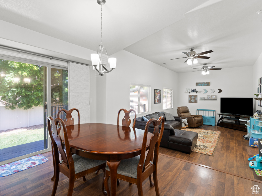Dining room with dark wood-style flooring, a ceiling fan, and a chandelier