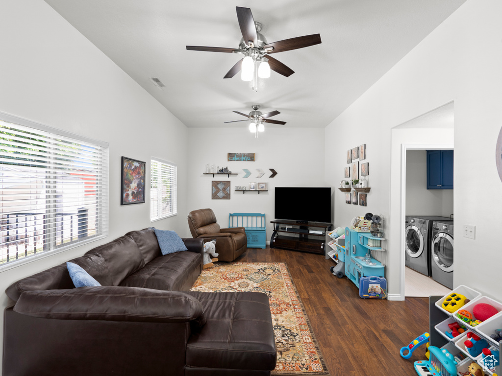 Living room featuring washing machine and dryer, ceiling fan, and dark wood-style floors