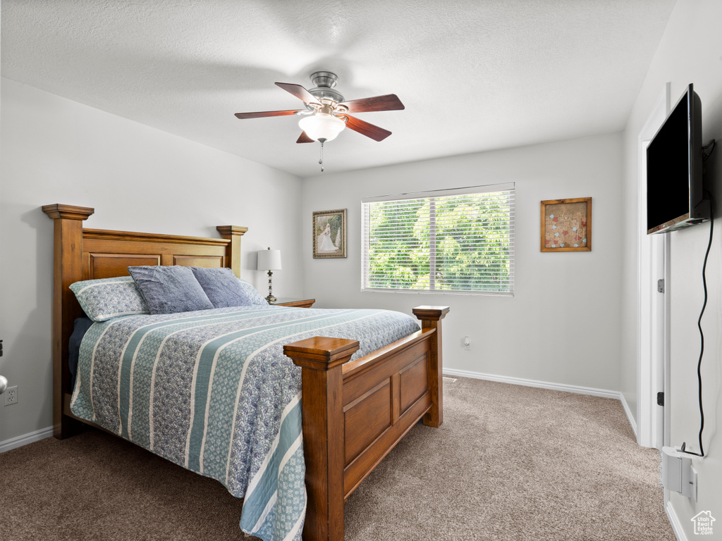Bedroom with carpet, baseboards, and a ceiling fan