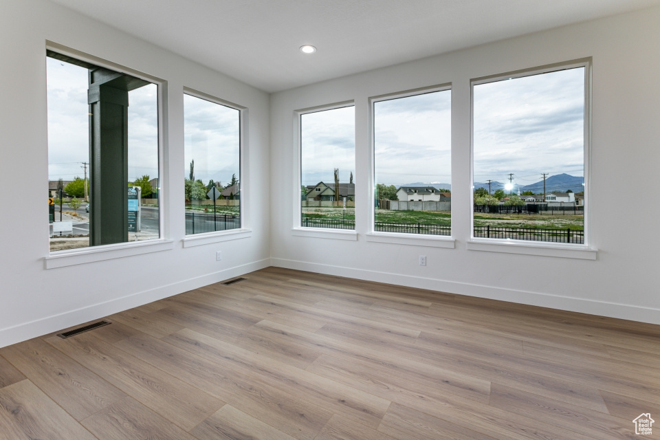 Unfurnished room with baseboards, light wood-style floors, and recessed lighting