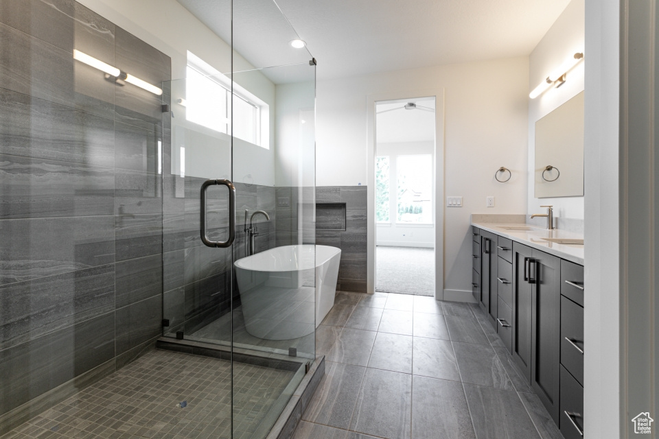Bathroom with ceiling fan, double vanity, a shower stall, a soaking tub, and recessed lighting