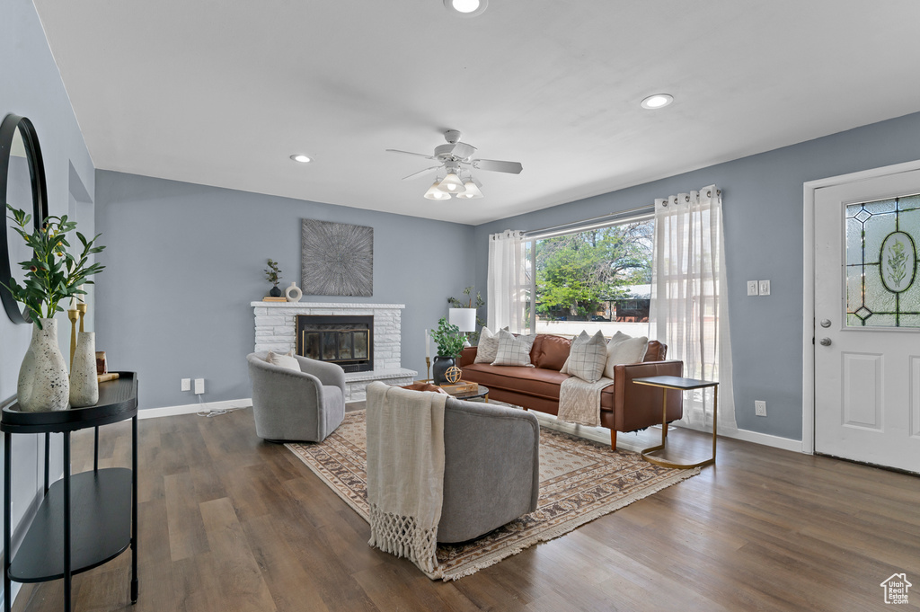 Living area featuring ceiling fan, dark wood-style flooring, recessed lighting, baseboards, and a stone fireplace