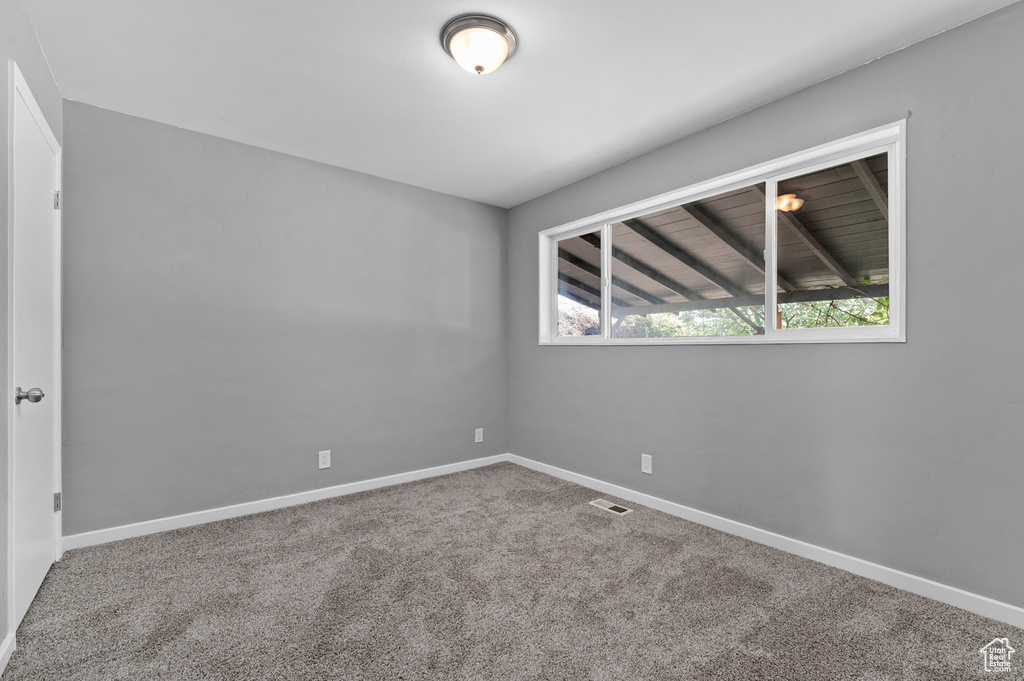 Empty room featuring carpet flooring and baseboards