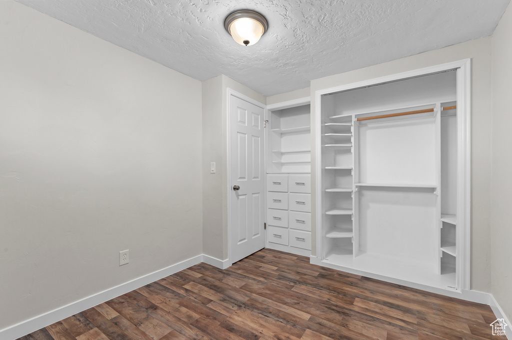 Walk in closet featuring dark wood-style floors