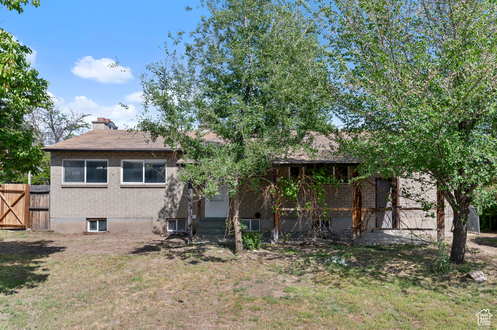 Back of property with a chimney and roof with shingles