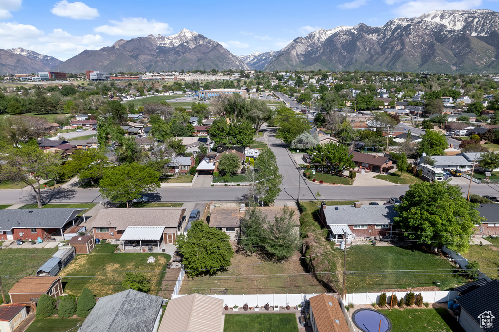 Aerial view of property and surrounding area with mountains and nearby suburban area