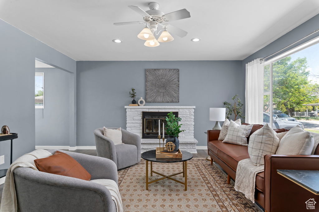 Living room featuring recessed lighting, a glass covered fireplace, a ceiling fan, baseboards, and wood finished floors