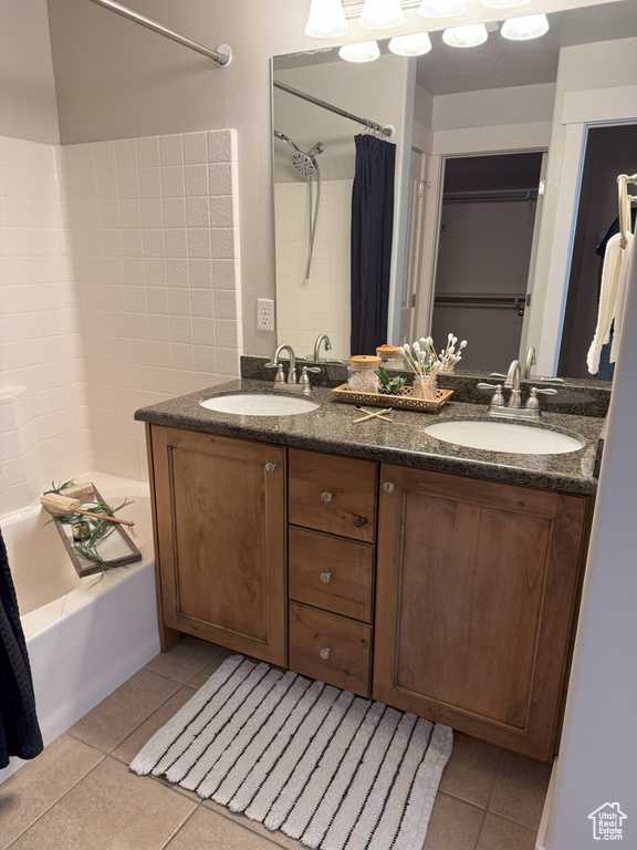 Bathroom featuring tile patterned floors, double vanity, and shower / tub combo with curtain