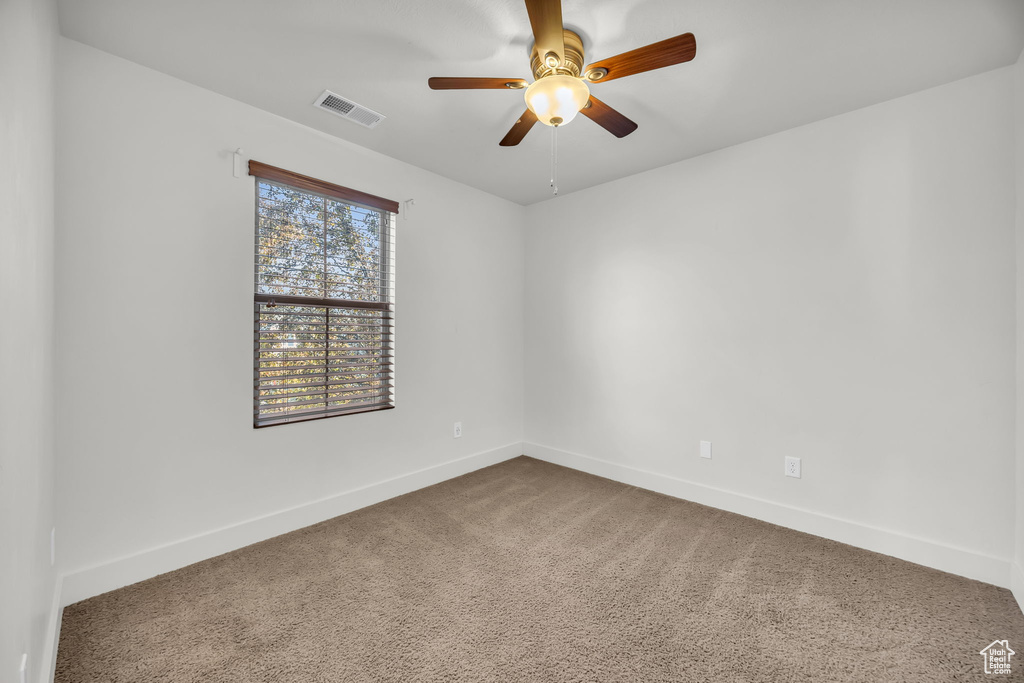 Spare room featuring baseboards, carpet, and a ceiling fan