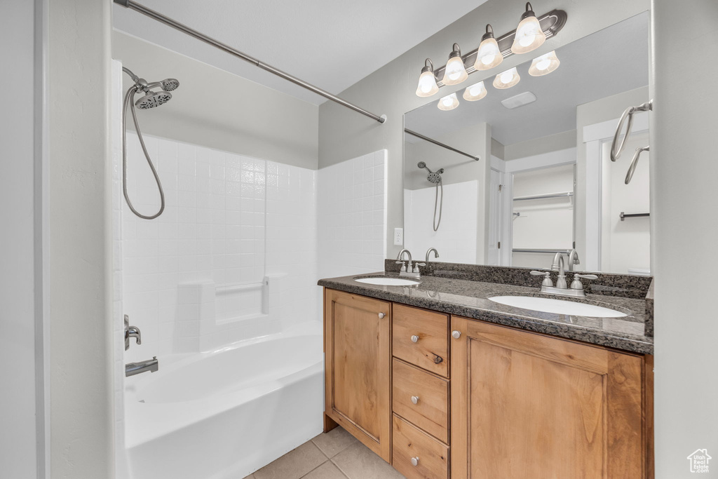 Bathroom with tile patterned flooring, shower / tub combination, and double vanity