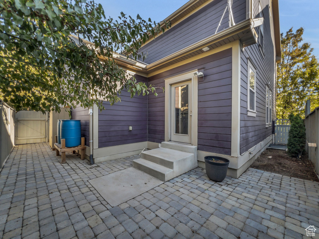 Back of property featuring a gate, fence, and a patio