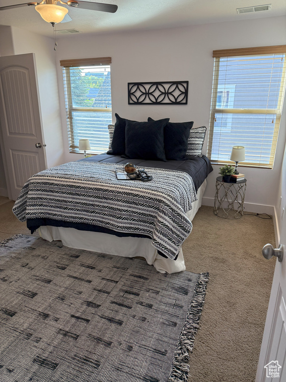 Carpeted bedroom with ceiling fan and baseboards