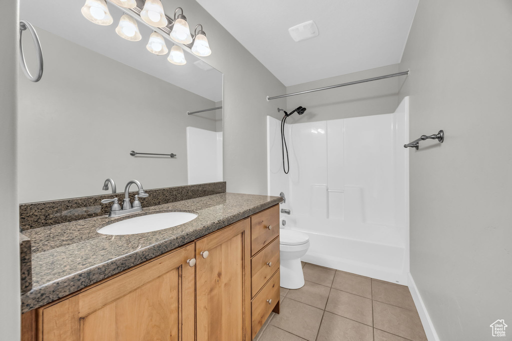 Bathroom featuring tile patterned floors, vanity, bathing tub / shower combination, toilet, and baseboards