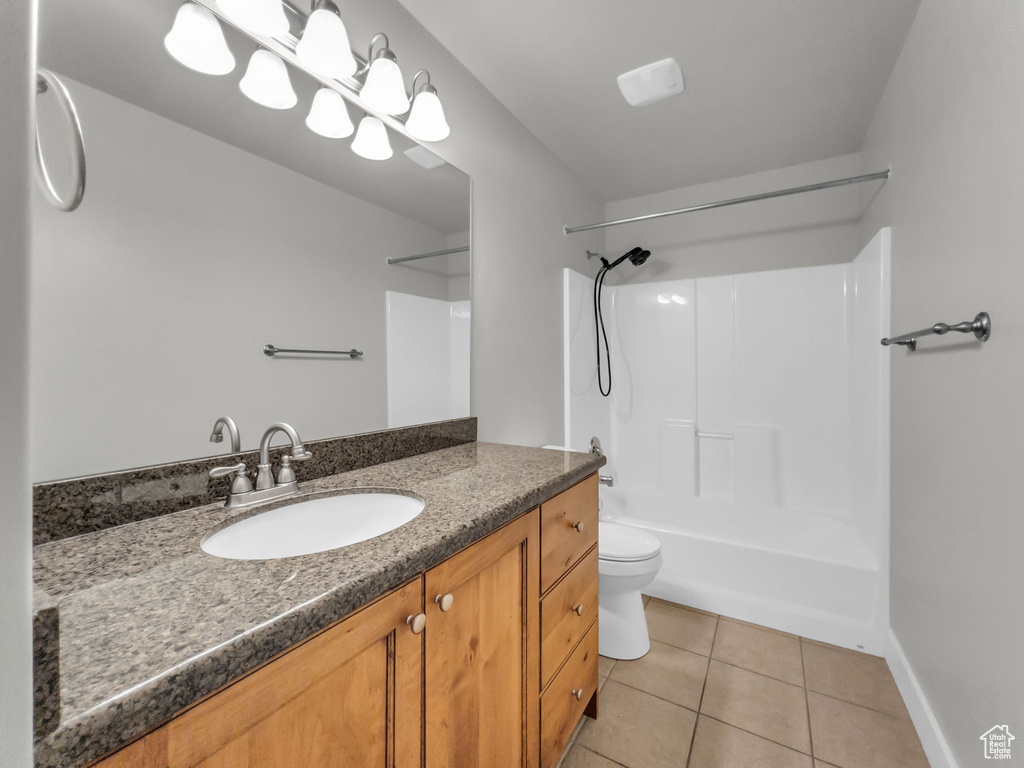Full bath featuring tile patterned flooring, vanity, toilet, shower / tub combination, and baseboards