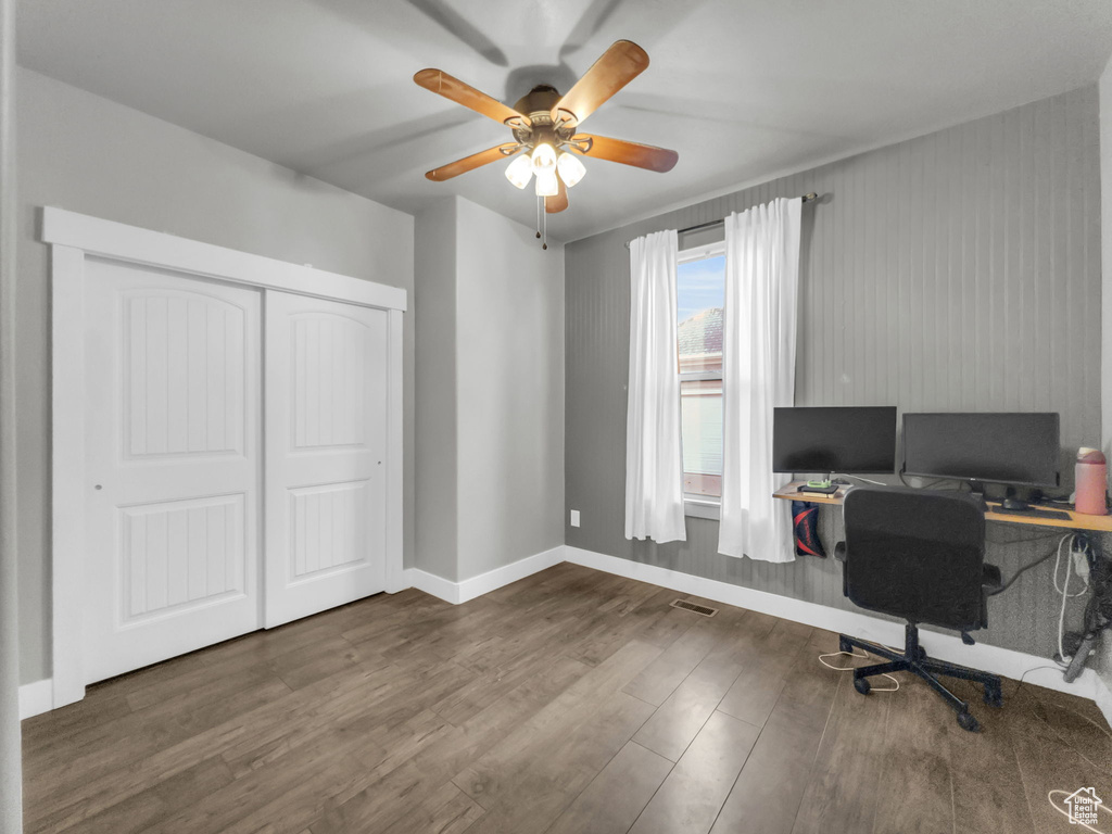 Office space featuring wood finished floors, a ceiling fan, and baseboards