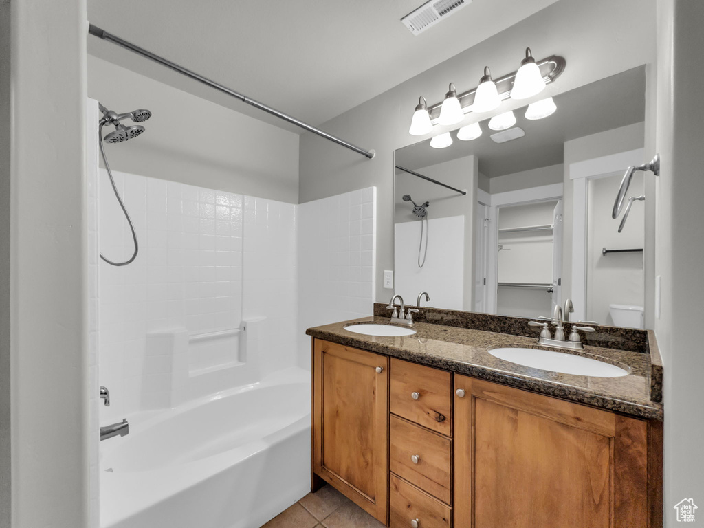 Full bath featuring shower / tub combination, tile patterned flooring, and double vanity