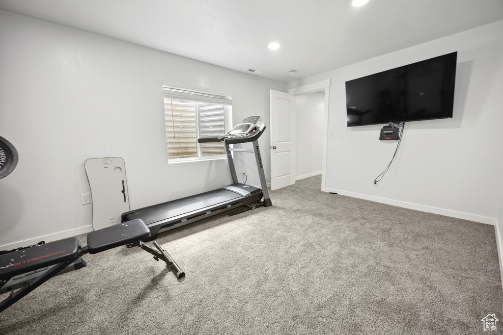 Exercise area featuring carpet floors, baseboards, and recessed lighting