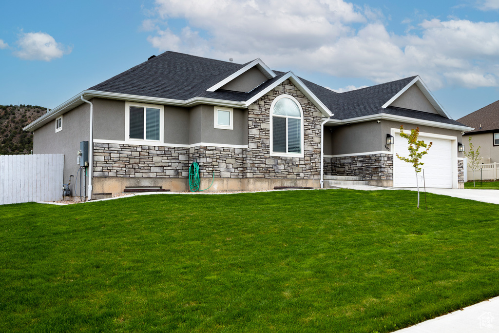 Single story home with stucco siding, stone siding, an attached garage, and concrete driveway