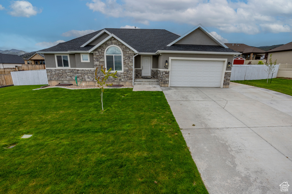 Single story home with stucco siding, stone siding, concrete driveway, and a garage