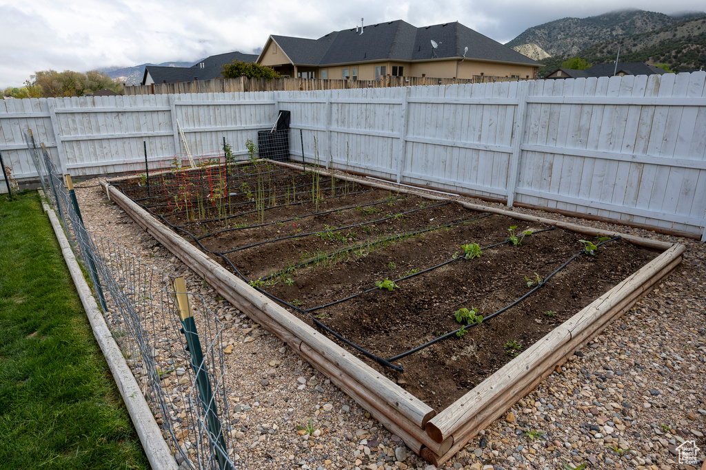 Fenced backyard with a vegetable garden and a mountain view
