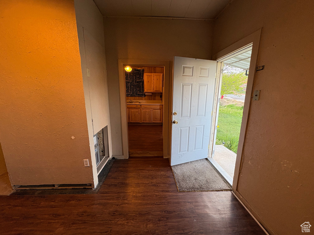 Foyer with dark wood-style flooring and a textured wall