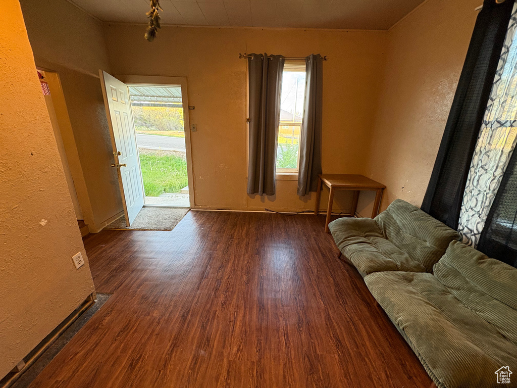 Living area with wood finished floors, baseboards, and a textured wall