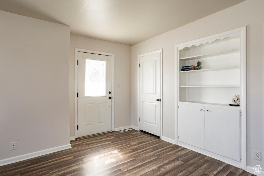 Entryway with dark wood finished floors and baseboards