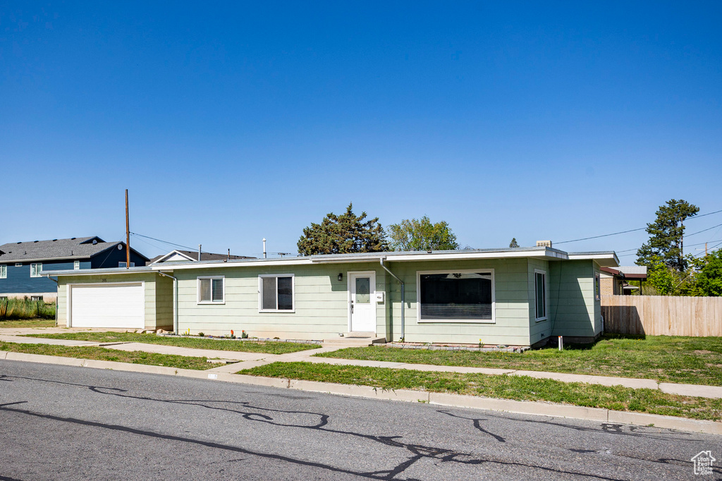 Ranch-style home with fence, an attached garage, and concrete driveway