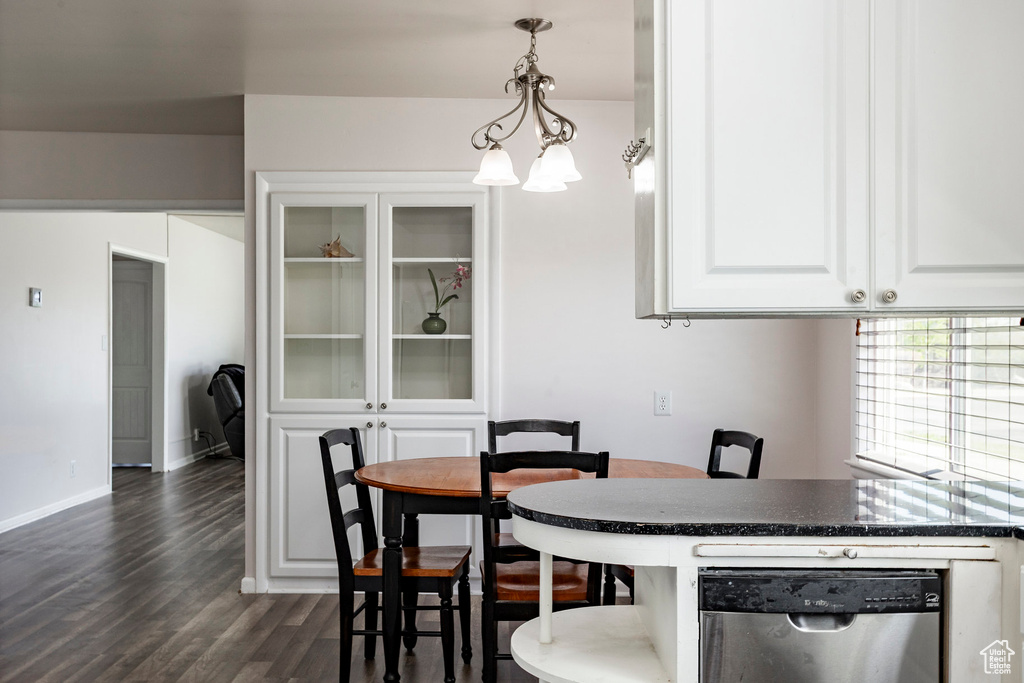 Dining room with dark wood-type flooring and baseboards