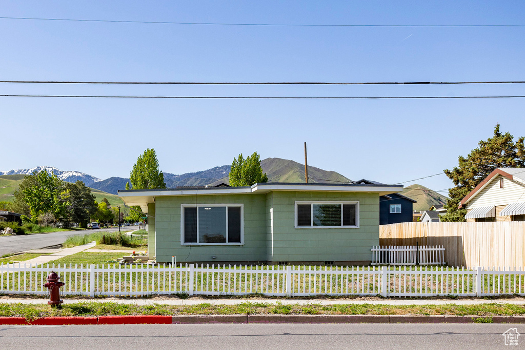 View of front of property featuring a mountain view and a fenced front yard