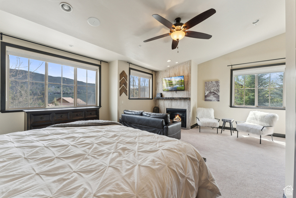 Carpeted bedroom with vaulted ceiling, a fireplace, recessed lighting, and a ceiling fan