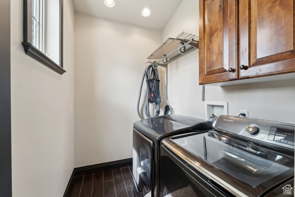 Clothes washing area featuring washer and clothes dryer, cabinet space, dark wood-style floors, baseboards, and recessed lighting