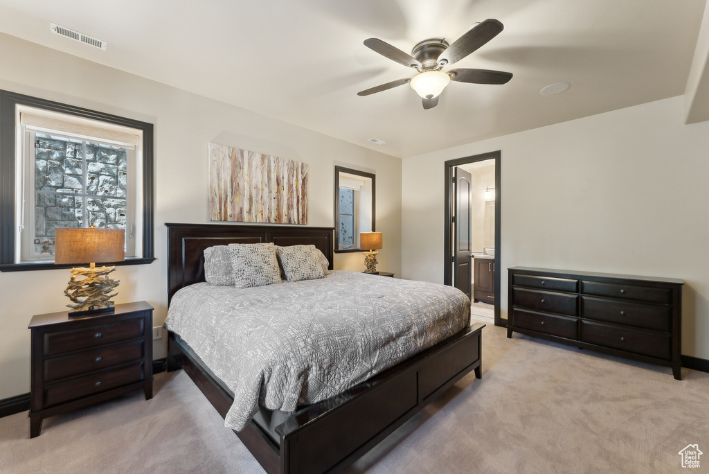 Carpeted bedroom featuring baseboards, a ceiling fan, and ensuite bath