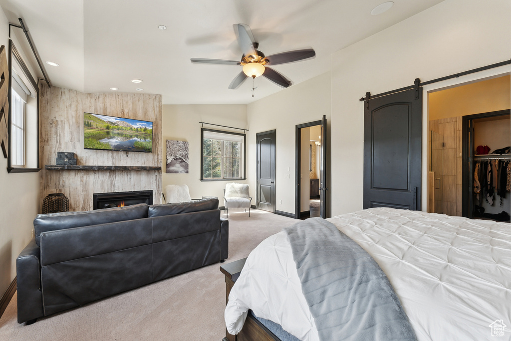 Bedroom with carpet floors, a barn door, a fireplace, recessed lighting, and baseboards