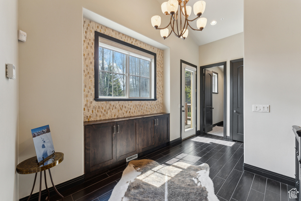 Foyer featuring wood tiled floors, baseboards, and a chandelier