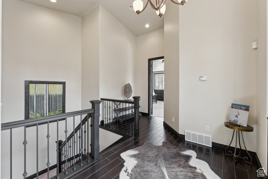 Hallway featuring an upstairs landing, a chandelier, wood finished floors, recessed lighting, and baseboards